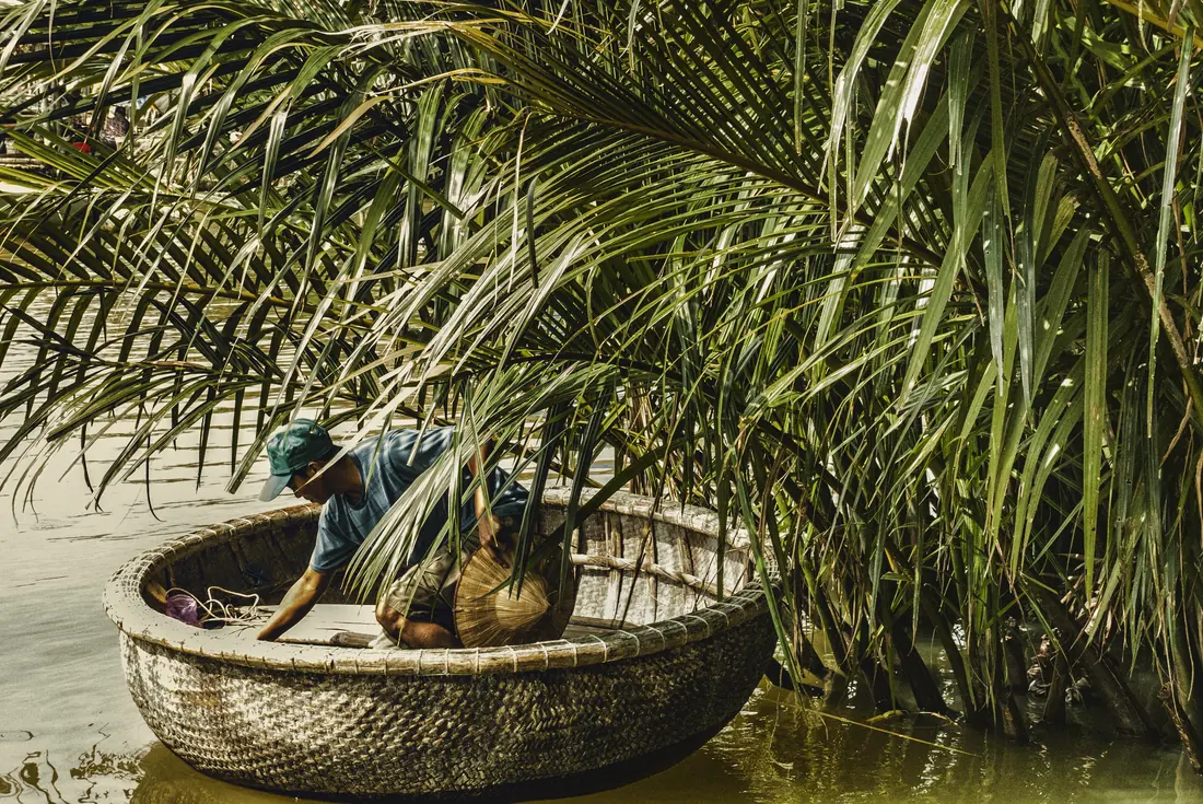 A traditional Vietnamese bamboo basket boat beside a bamboo forest